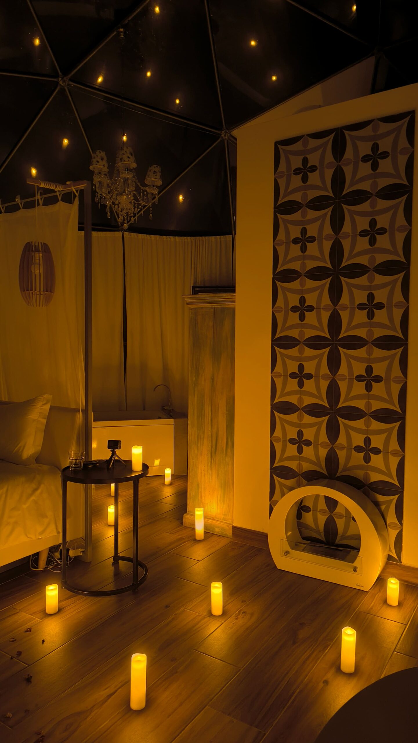 Geodesic dome interior set for a proposal with candles and a heart of rose petals on the bed