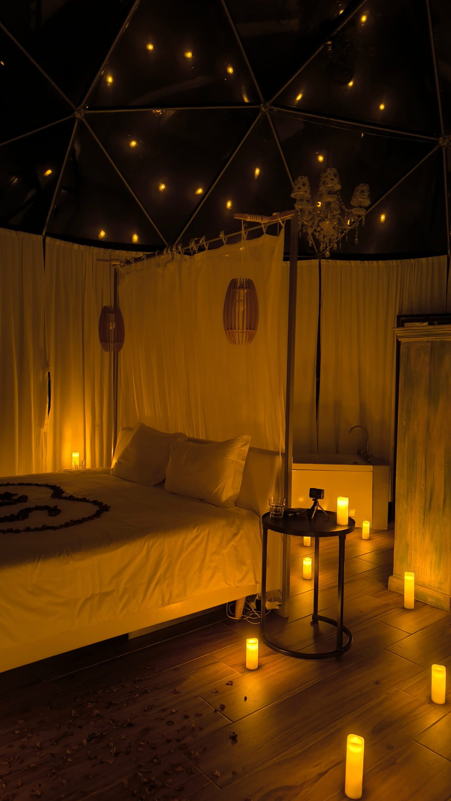 Bed decorated with a heart of rose petals beneath the starlit dome ceiling